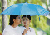 Two girls use an umbrella to protect themselves from the sun on the Kurukshetra University campus