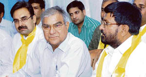 Chief of the media cell of the Haryana Janhit Congress Rann Singh Mann (centre) addresses a press conference in Karnal on Tuesday. 