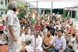 Members of the Indian National Trade Union Congress (INTUC) hold a dharna outside the office of assistant labour commissioner in Ludhiana on Wednesday.