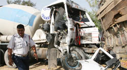 A traffic police official stands near the spot where a truck rammed into another truck parked on the road near IP park, Sarai Kale Khan in the Capital