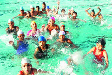 Children enjoy a splash in swimming pool as the mercury rises in Jalandhar on Thursday.