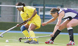Asunta Lakra of India (left) vies for the ball with Rachel Dawson of the US during their women's hockey Olympic qualifying match in Kazan