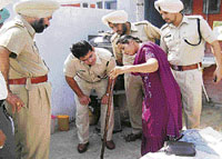 Pardeep Kaur, a relative of the deceased, shows the police the stick allegedly used in the crime in Ludhiana on Friday.