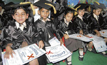 Tiny tots hold their degrees during a graduation ceremony at GRD Academy in Ludhiana on Friday.