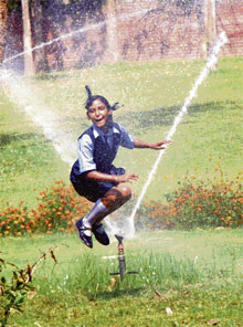 To beat the heat, a schoolgirl skips over a fountain stream in Chandigarh on Saturday.