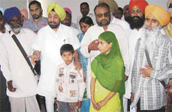 Lok Bhalai Party chief Balwant Singh Ramoowalia, along with Avtar Singh (9), Sandeep Kaur (13) and their father Rajinder Singh (orange turban), talks to mediapersons at Sunam