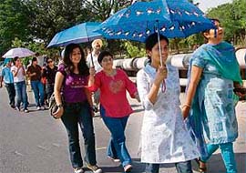 Spectators carry umbrellas to save themselves from the heat