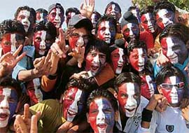 Cricket fans paint the faces to cheer their team