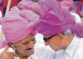Two elderly persons share a lighter moment during a function organised by the Bharatiya Multani Parimandal Mahasabha to honour martyrs families in Karnal