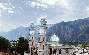 A mosque under construction amidst majestic mountains in Kishtwar.
