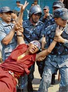 Nepalese policemen detain a Tibetan monk in exile during an anti-Chinese demonstration near the consular section of the Chinese Embassy in Kathmandu on Sunday.
