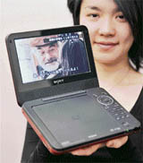 A Sony employee displays the new portable DVD player "DVP-FX720", equipped with a high-resolution 7-inch LCD display and up to 5-hour long battery at the company's headquarters in Tokyo