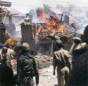 Jawans of the Jammu and Kashmir Police inspect the damaged house where two Hizbul Mujahideen militants were killed during an encounter in Pattan on Monday. 