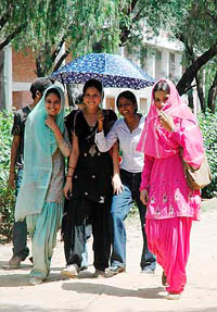 Girls share an umbrella for protection against sunlight at Punjabi University, Patiala, on Tuesday.