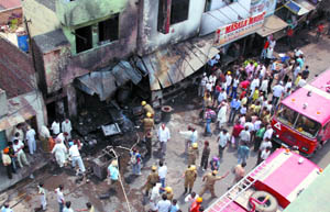 The Delhi Fire Service personnel try to control the fire in a shop at Jheel in East Delhi on Tuesday. 