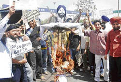 Members of various Sikh organisations burn an effigy of Manjit Singh, a former education minister, in Jammu on Tuesday.