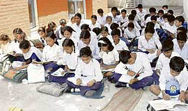 Braving the Elements: Students of Government High School, Hallo Majra, Chandigarh, attend their class sitting on the floor out in the open in blistering heat.