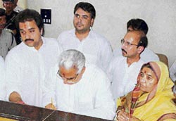 Former Chief Minister Bhajan Lal, flanked by wife Jasma Devi and son Kuldeep Bishnoi, MP (left), files his nomination papers for the byelection to the Adampur seat in Hisar