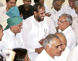 Chief Minister Bhupinder Singh Hooda and former Chief Minister Om Prakash Chautala shake hands inside the office of the returning officer for the Adampur assembly segment in Hisar on Thursday.