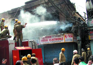 Firemen douse flames at Sadar Bazar Market in the Capital on Friday. 