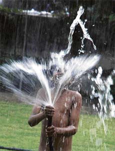 A child plays with water to beat the heat at the mini-secretariat in Karnal