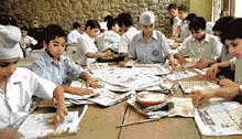 Students of GMSSS-22 engage in making paper envelopes from newspaper waste in Chandigarh on Saturday.