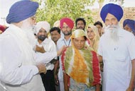 Chief Minister Parkash Singh Badal on Saturday consoles a woman whose mother was burnt alive in a devastating fire in the fields at Tharajwala village in Muktsar