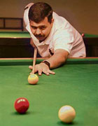 Cueist Ajay Singla aims at the ball during a billiards match at Chandigarh Club on Sunday.