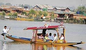 With temperature going up in the valley, a family takes a ride in a shikara at the Dal Lake on Sunday.