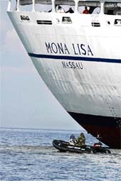 Members of Latvias coast guard inspect the stranded Bahamas-registered cruise ship Mona Lisa off Latvias northwest coast near Kolka, about 200 km from the capital Riga, on Sunday. The ship with 984 persons on board ran aground off the coast of Latvia on Sunday. All passengers and crew were safe, the coast guard said. 
