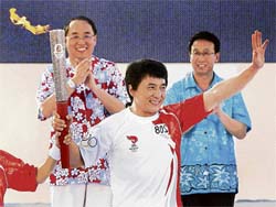 Olympic torch carrier superstar Jackie Chan waves to the crowds on reaching the last check-point at the Tianya Haijiao, a tourism landmark in Sanya, Hainan province, China on Sunday. The mainland China leg of the Olympic torch relay started in the southern island of Hainan on Sunday in what is expected to be a peaceful three-month journey to Beijing.  AP/PTI photo