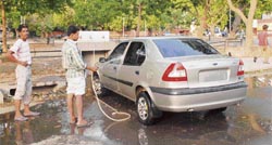 The domestic help of a car owner washing his vehicle at a public facility in Sector 24-D market, Chandigarh