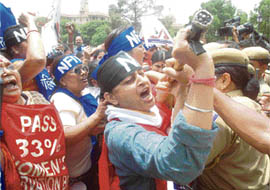 Women activists of the National Federation of India shout anti-UPA government slogans during a protest outside the Parliament house demanding the passage of the women reservation Bill in New Delhi on Monday.