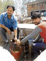 Employees at Manimajra Service Station drain out water from a diesel tank.
