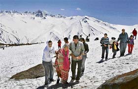 An elderly tourist being helped by her dear ones as they walk on snow-capped mountains at Gulmarg in Jammu and Kashmir