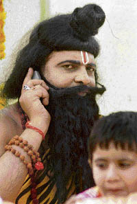 A man dressed as Lord Parshuram talks on his mobile phone during a shobha yatra in Ludhiana on Tuesday.
