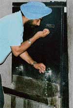 A UT employee drinks water from a water cooler placed inside the womens toilet at the additional deluxe building in Sector 9, Chandigarh.