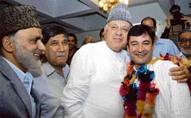 NC patron Farooq Abdullah embraces Javed Ahmad Dar, who joined the party after quitting the PDP, in Srinagar on Wednesday.