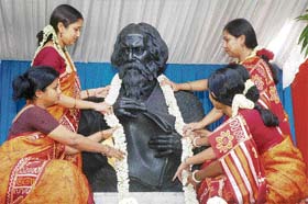 Students of Rabindra Bharati University decorate the statue of Rabindra Nath Tagore on the eve of his 148th birth anniversary at Jorasanko Thakur Bari, birth place of Tagore, in Kolkata