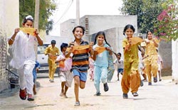 Children carry election symbols of political parties at Chak-Bhaktu village of Bathinda