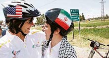 A cyclist from the US hugs an Iranian fellow member of the Follow the Women Foundation campaign during a ride for peace at al-Quneitra city in Golan Heights on Wednesday.