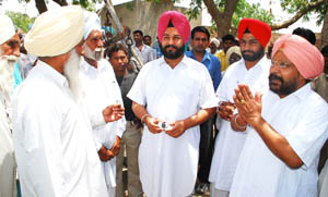 Congress MLAs Ajaib Singh Bhatti and Gurpreet Singh Kangar campaigning for their party candidates in village Har Raipur. 