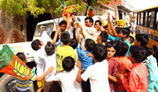 BJP activists distributing party flags and election material among children at village Bhucho-Kalan in Bathinda on Friday. 