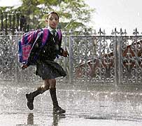 A schoolgirl scurries home after rain lashed Shimla on Friday.