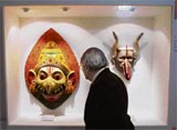 A man looks at masks from India displayed at an exhibition in the New Orient Museum in Lisbon