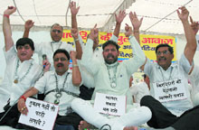 Traders wear chains and locks during a dharna against sealing at Town Hall in the Capital on Saturday.