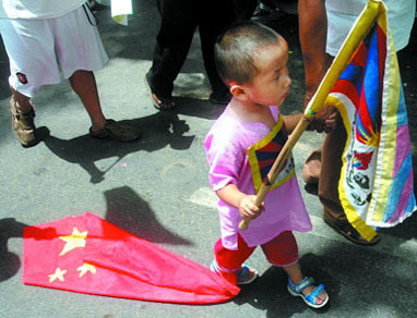 A Tibetan child in exile walks with a Chinese flag tied to his ankle during a protest in the Capital on Saturday.