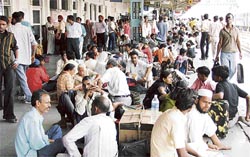 Passengers wait for trains to arrive at the railway station in Ludhiana