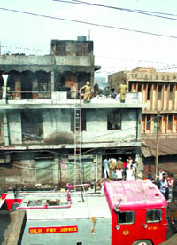 Firemen douse flames at a shoe factory at Wazirpur in the Capital on Sunday. 