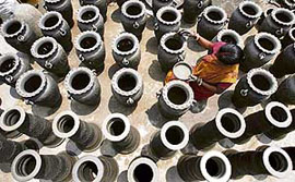 A potter gives final touches to an earthen pot at a workshop in Matigara village on the outskirts of Siliguri on Sunday.